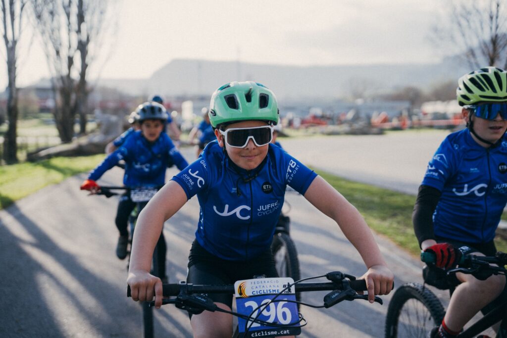 Jonge mountainbikers in blauwe Tactic-wielershirts